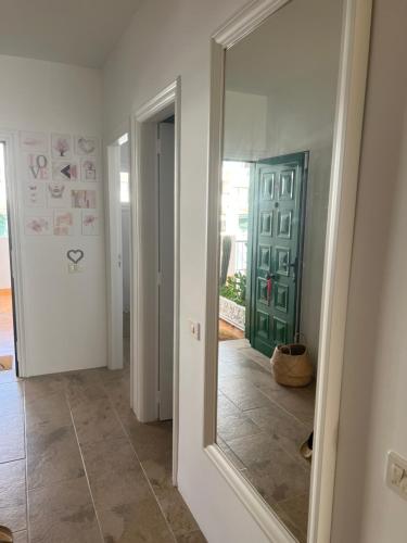 a hallway with a mirror and a green door at Luxueux Appartement à Ténérife Vue féerique sur l'océan à 360 degrés in Callao Salvaje