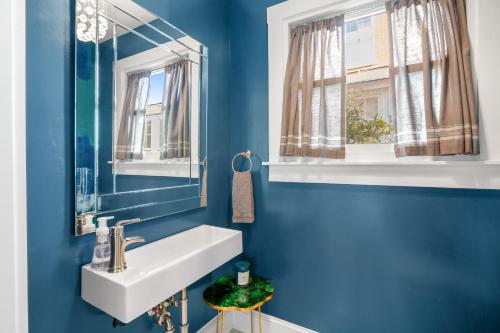 La salle de bains bleue est pourvue d'un lavabo et d'un miroir. dans l'établissement Anchors Aweigh, à Annapolis