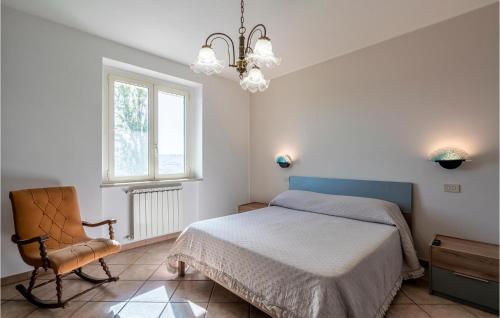 ein Schlafzimmer mit einem Bett, einem Stuhl und einem Fenster in der Unterkunft Cozy Home In Montenero Di Bisaccia With House A Panoramic View in Montenero di Bisaccia