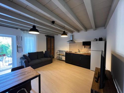 a living room with a couch and a kitchen at Borgovivo Il tuo Loft in centro città in Bergamo