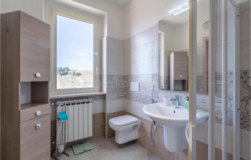ein Bad mit einem WC, einem Waschbecken und einem Fenster in der Unterkunft Cozy Home In Montenero Di Bisaccia With House A Panoramic View in Montenero di Bisaccia