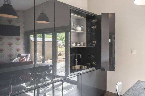 a kitchen with black cabinets and a sink at Garden Room Lodges in Alexandria