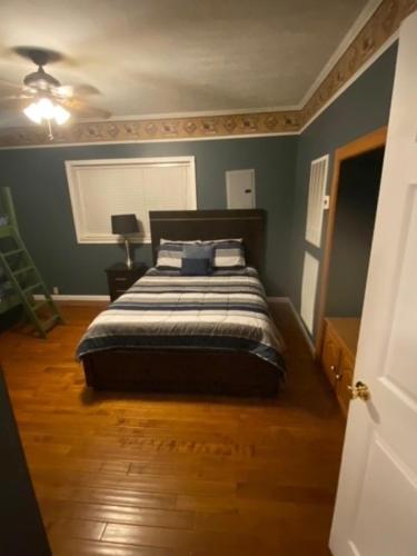 a bedroom with a bed with blue walls and wooden floors at Southern Charm in Cadiz