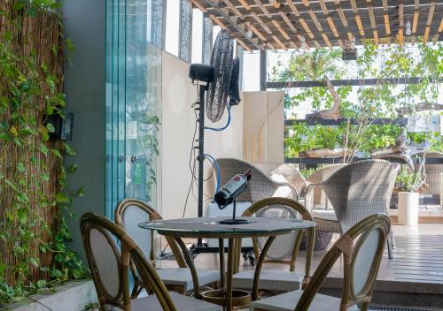 a table and chairs on a patio with a microphone at Hotel Perla Suite Santa Marta in Santa Marta