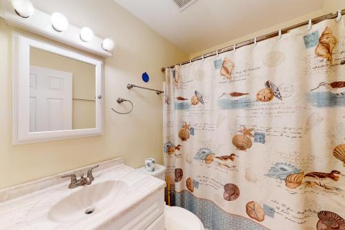 ein Bad mit einem Waschbecken und einem Duschvorhang in der Unterkunft Blue Dolphin 054 in Avon