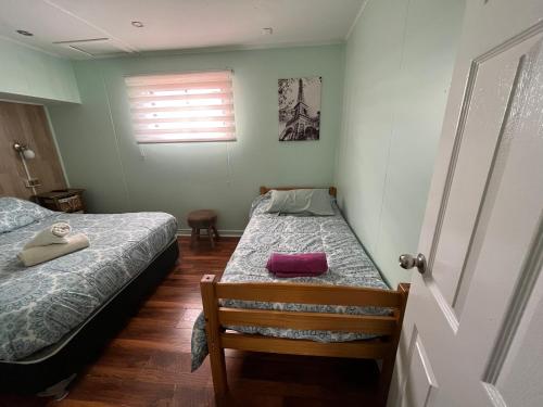 1 dormitorio con 2 camas individuales y ventana en Departamentos Patagonia en Puerto Natales