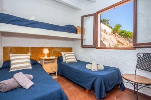 two beds in a room with a view of a beach at Vacaciones en Cala Morell in Cala Morell