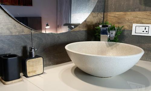 a white bowl on a bathroom sink with a mirror at Studio Mirador, todo lo que necesitas para disfrutar in Tarija