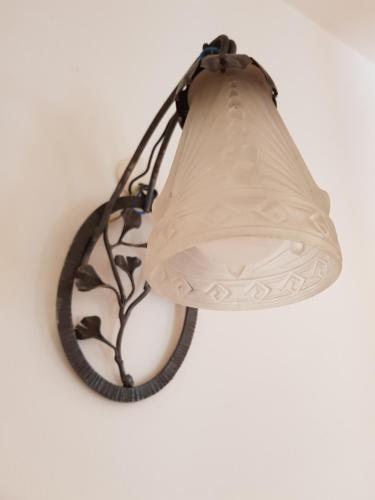 a lamp hanging on a wall with a white wall at La Trémière, maison de village, sauna, vue garrigue in Bouzigues