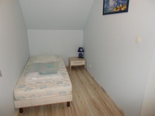 a small bedroom with a bed and a small table at La Ferme de Genarville in Bouville