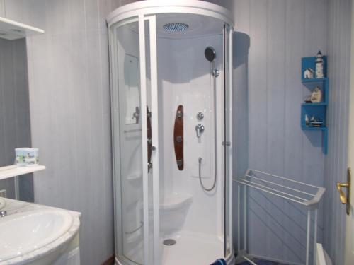 a white shower in a bathroom with a sink at La Ferme de Genarville in Bouville