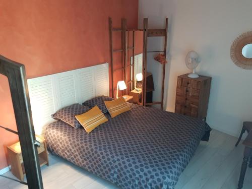 een slaapkamer met een bed met kussens erop bij La Trémière, maison de village, sauna, vue garrigue in Bouzigues