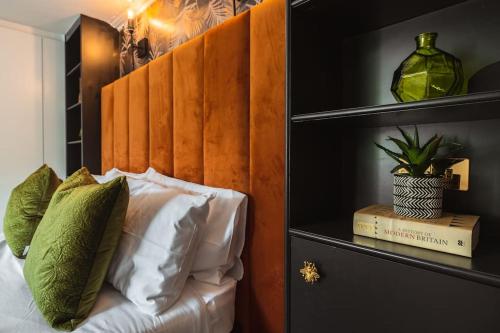 グラスゴーにあるThe West End Loft - 5* Retreat - Private Parking!のベッドルーム1室(木製ヘッドボード、ソファ、枕付)