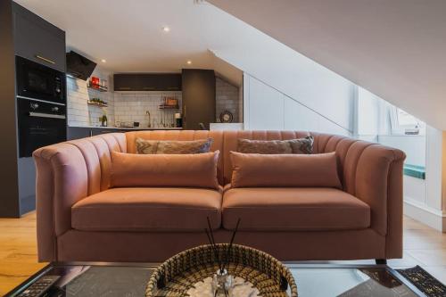 a brown couch sitting in a living room at The West End Loft - 5* Retreat - Private Parking! in Glasgow