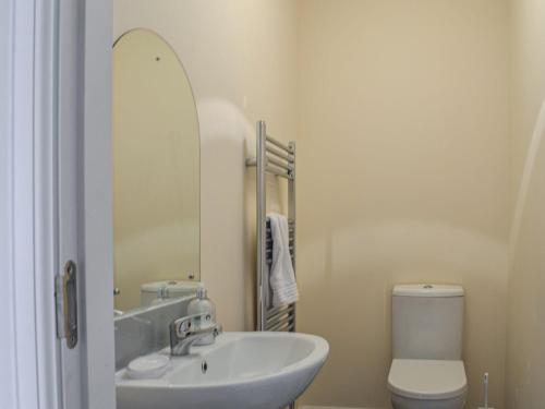 a bathroom with a sink and a toilet and a mirror at Golf View in Aboyne