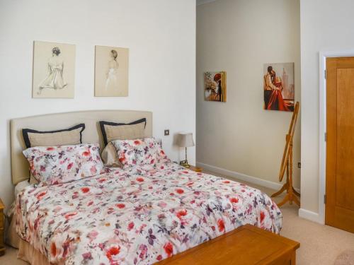 a bedroom with a bed with red flowers on it at Apartment 8, The Bay in Torquay