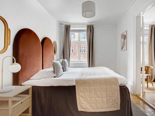 a bedroom with a large bed and a window at Sanders Stage - Chic Three-Bedroom Apartment Near Nyhavn in Copenhagen