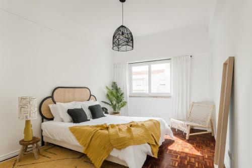 Un dormitorio con una cama con una manta amarilla. en Casa Boma Lisboa - Design & Spacious Apartment With Balcony - Alvalade II en Lisboa