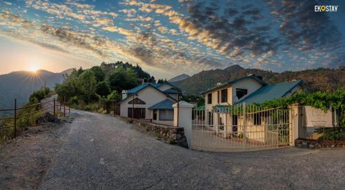 a dirt road with a fence and some houses at Karinya Villas in Nainital
