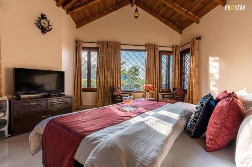 sypialnia z dużym łóżkiem i telewizorem w obiekcie Karinya Villas w mieście Nainital