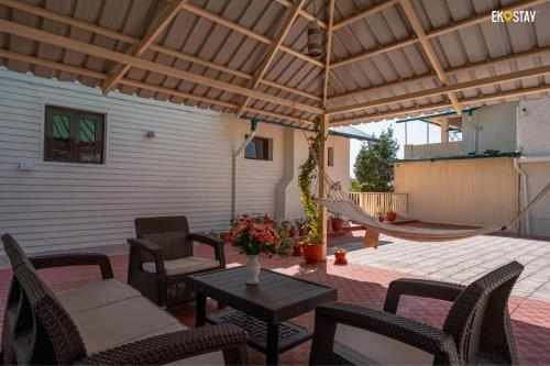 a patio with chairs and a table and a hammock at Karinya Villas in Nainital