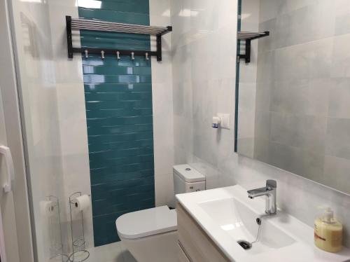 a bathroom with a toilet and a sink and a mirror at Apartamento Armiñán Ronda- parking opcional in Ronda