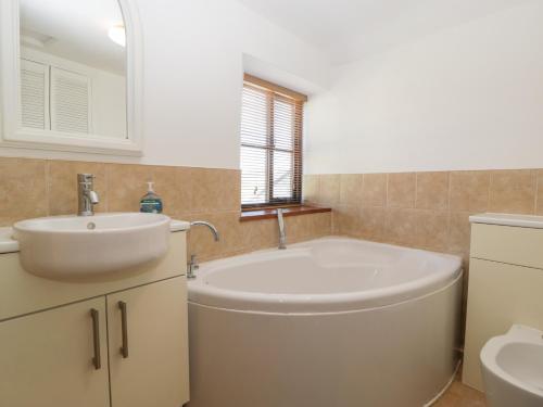 a bathroom with a large tub and a sink at Wesley House in Shepton Mallet