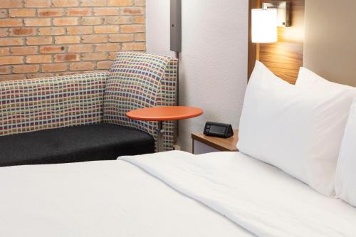 a hotel room with a bed and a chair at Holiday Inn Express - San Antonio Airport by IHG in San Antonio