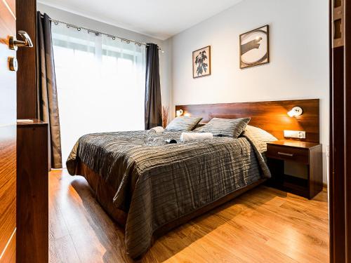 Un dormitorio con una cama grande y una ventana en VisitZakopane - Dubaj Apartment, en Zakopane