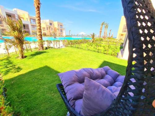 a purple pillow sitting on a chair in a yard at Luxurious Sea view 2 BR & private Garden to the pool at Mangroovy in Hurghada
