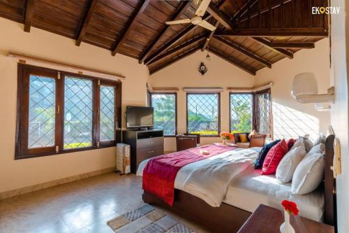 a bedroom with a large bed and a tv at Karinya Villas in Nainital