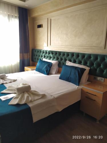 a bedroom with a large bed with blue pillows at THE MOSS Hotel in Istanbul