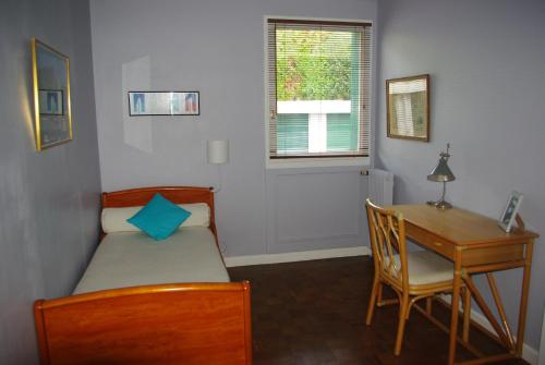 1 dormitorio con cama, escritorio y mesa en Appartement Résidence du Lac, en San Juan de Luz