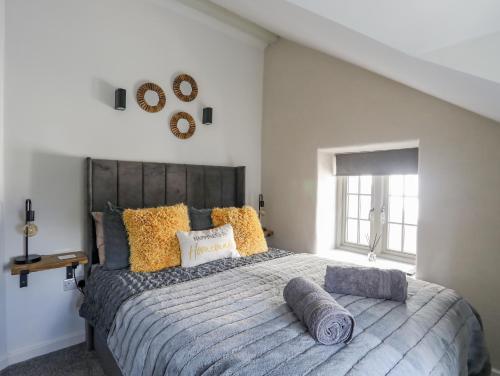ein Schlafzimmer mit einem großen Bett mit Kissen darauf in der Unterkunft Lleiniog Cottage in Beaumaris