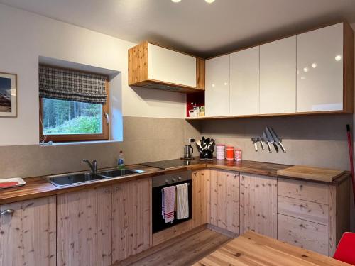 a kitchen with wooden cabinets and a sink at Casa Alfredino in Rocca Pietore