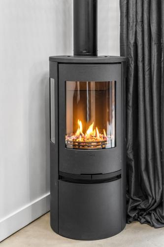 a black stove with a fire in a room at Les Petits Chalets in Val-des-Lacs