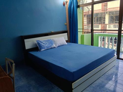 a bed in a room with a blue wall at Yuri Guesthouse in Jomtien Beach