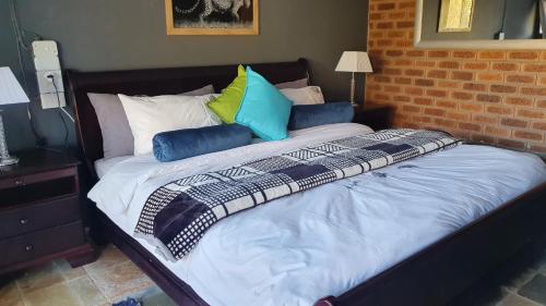 a bed with colorful pillows on top of it at 113 Zwartkloof Private Game Reserve Bela-Bela in Bela-Bela