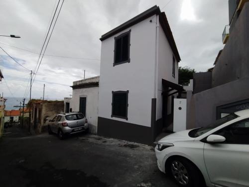 a car parked in front of a white building at Downtown Tiny House in Funchal