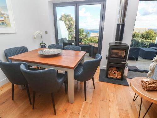 a dining room with a table and a wood stove at Seafield, St. Ives in Carbis Bay