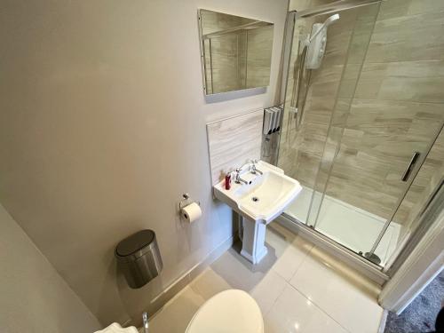 a bathroom with a sink and a shower and a toilet at Market Street Casa by KP in Nottingham