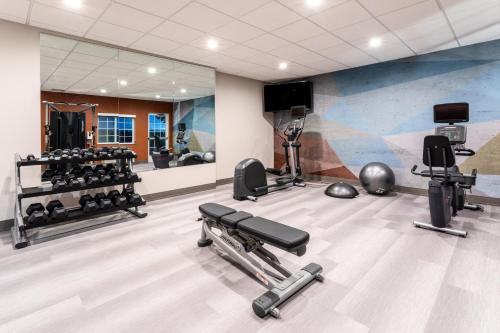 a gym with several tread machines and a mirror at Candlewood Suites Grand Junction by IHG in Grand Junction