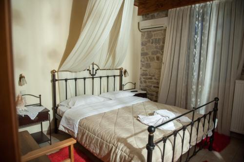 a bedroom with a bed and a window with curtains at Ουρανια Τασιου in Mikro Chorio