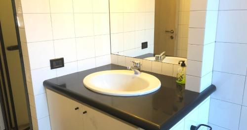 een badkamer met een wastafel en een spiegel bij Appartamento moderno esclusivo vicino stazione e centro città in Alessandria