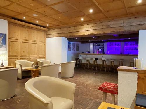 a room with chairs and a bar with purple lights at 42m2 Alpenschick mit Balkon, Ausblick, Pool - E405 in St. Moritz