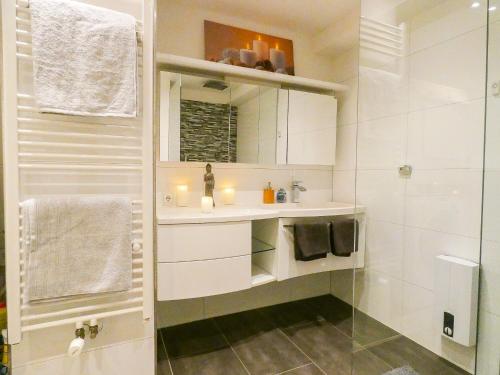 a white bathroom with a sink and a shower at *****Luxus-Flat im Herzen von Hilden in Hilden