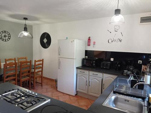 une cuisine avec un réfrigérateur blanc et un plan de travail dans l'établissement Les Gîtes du Triskell, gîte du Feu, à Sainte-Tréphine