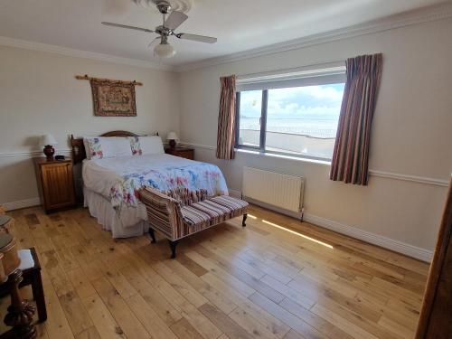 a bedroom with a bed and a window and a chair at High Tide in Duncannon
