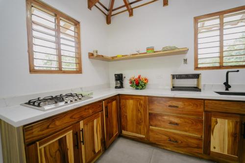 a kitchen with wooden cabinets and a stove top oven at Dreamy Contentment in Matapalo