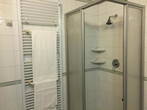 a shower with a glass door and a towel at Hotel Terme Marconi in Montegrotto Terme